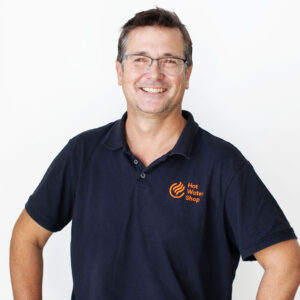 head shot of Tim from Hot water shop smiling directly at camera wearing a hot water shop branded navy polo shirt.